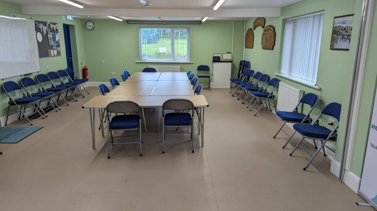 Hwb Rhuddlan meeting room set up with tables and chairs