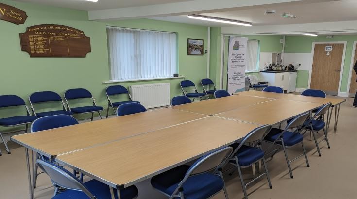 Hwb Rhuddlan room set up with tables and kitchen area visible